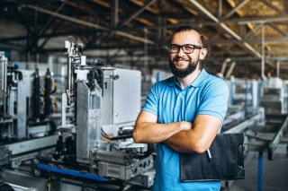 Apprentice standing in fron of machines