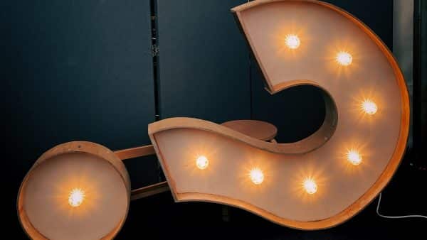 Illuminated question mark sign with light bulbs