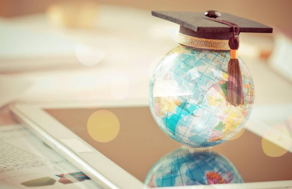 Globe with a graduation cap on a desk – symbolic image for studying and certification abroad